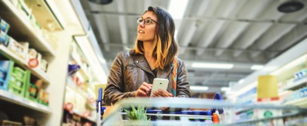 woman pushing a shopping cart on phone