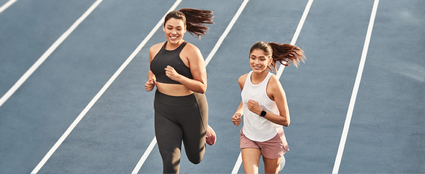 two young women jogging on a track