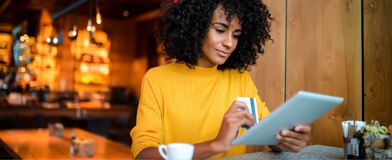 woman on tablet with debit card